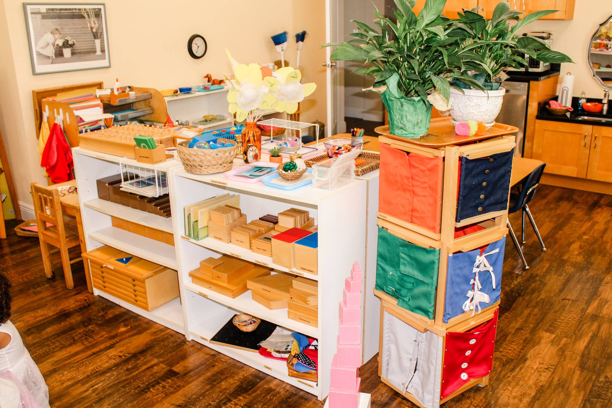 Montessori classroom shelves with sensorial materials and pink tower